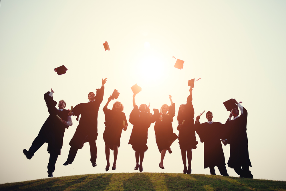 A group of graduates are throwing their caps in the air.