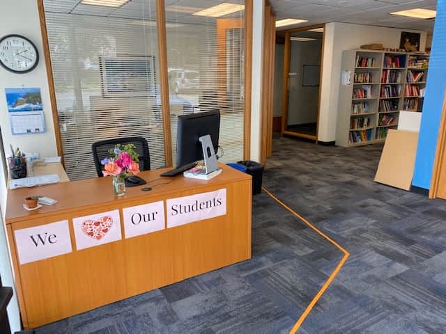 A desk with a sign on it that says we love our students