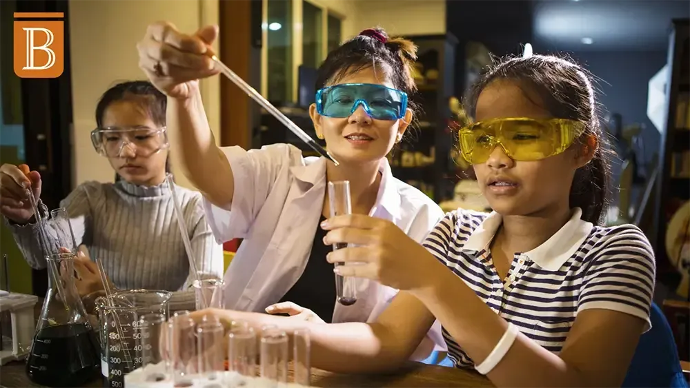 teacher working with students on a science experiment