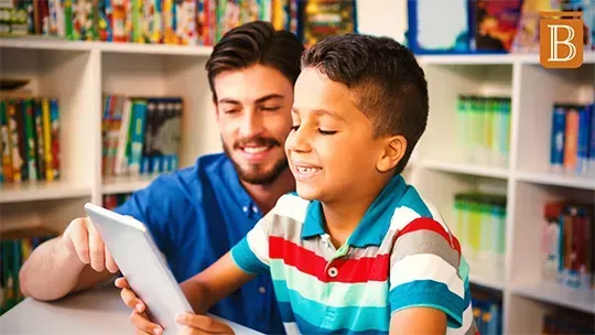 teacher helps young student on ipad