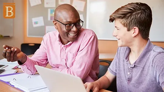 teacher and student working at a desk