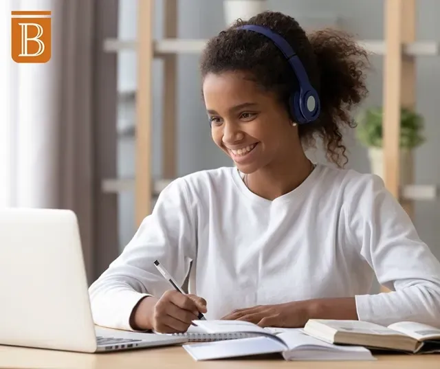 student wearing headphones working at a computer