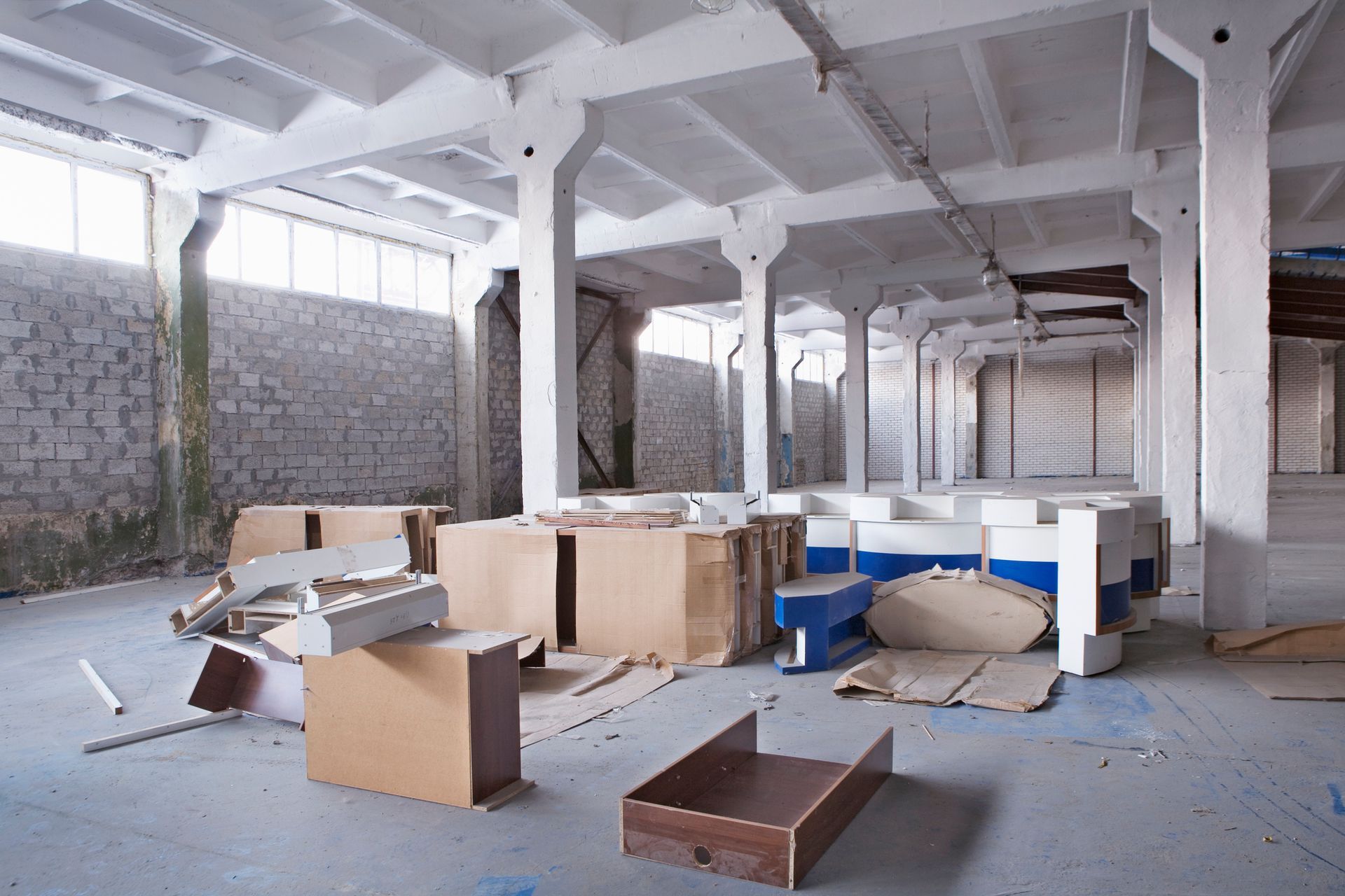 An empty warehouse with a lot of cardboard boxes on the floor