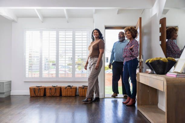 A group of people are standing in a living room looking at a house.