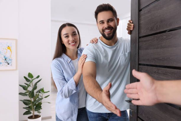 A man and a woman are standing in front of a door.