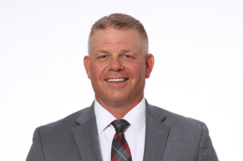 A man in a suit and tie is smiling for the camera