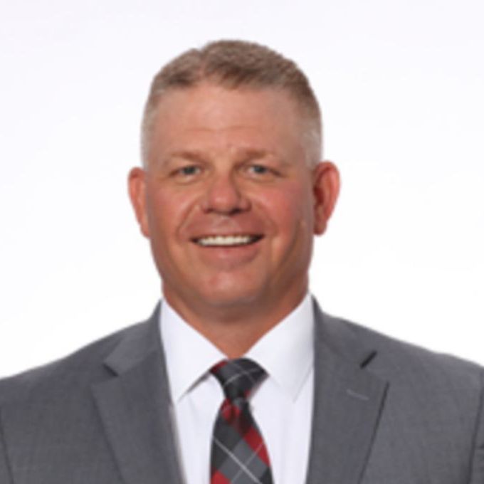 A man in a suit and tie is smiling for the camera