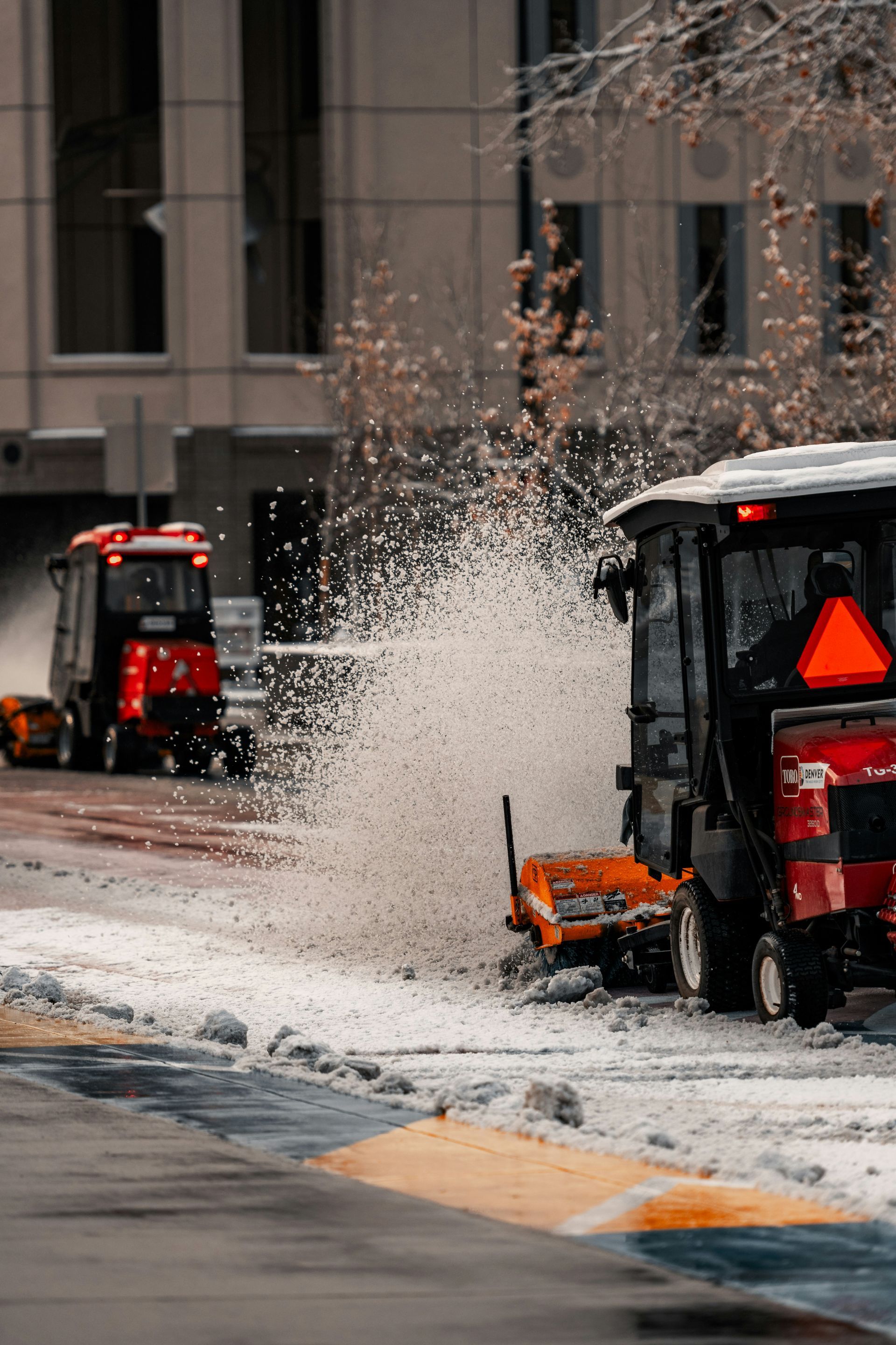 A snow plow is parked on the side of the road