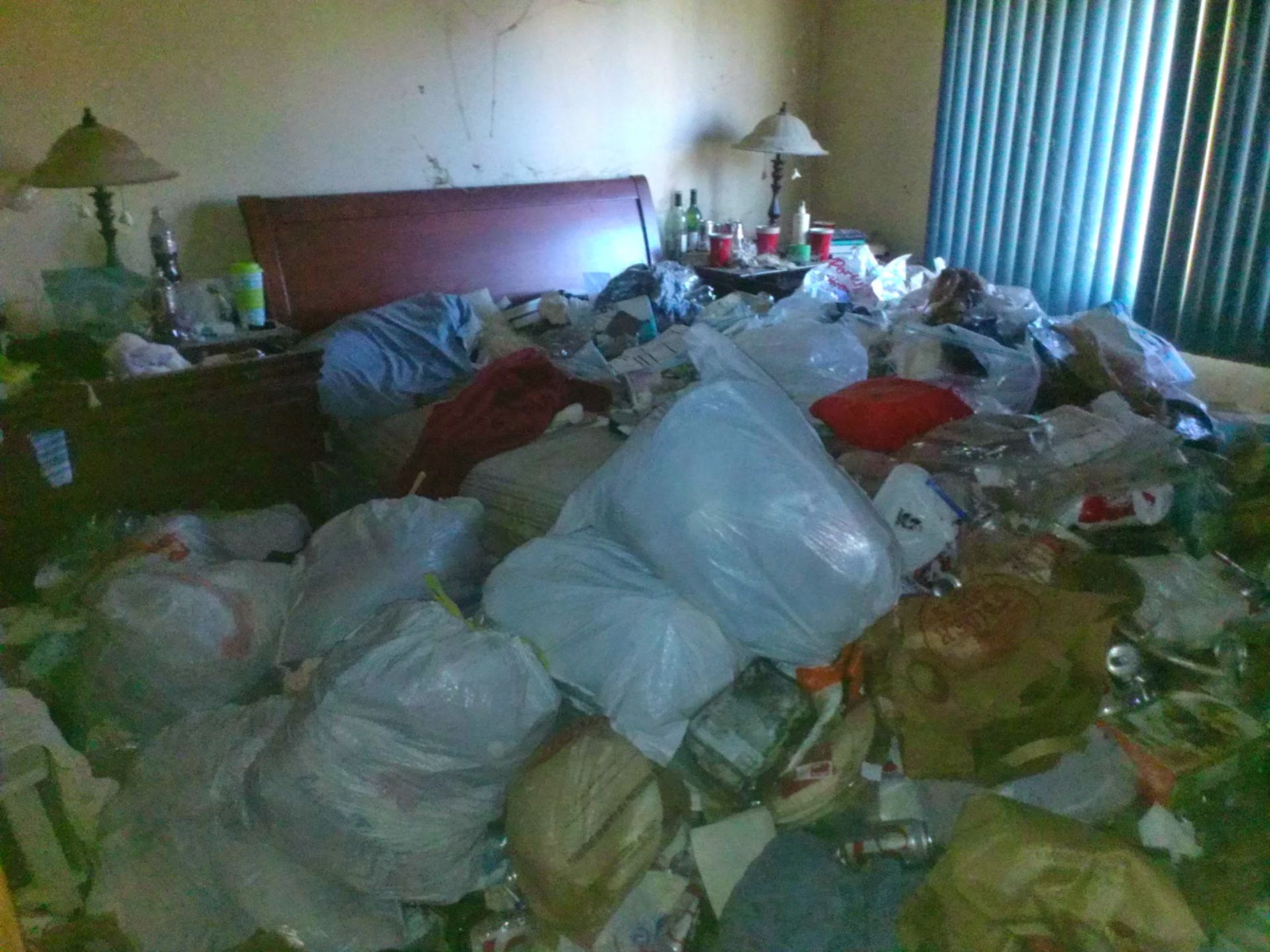 A bedroom with a lot of trash on the floor