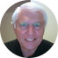 A man with white hair and glasses is smiling in a circle.