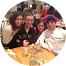 A group of people are posing for a picture while sitting at a table.
