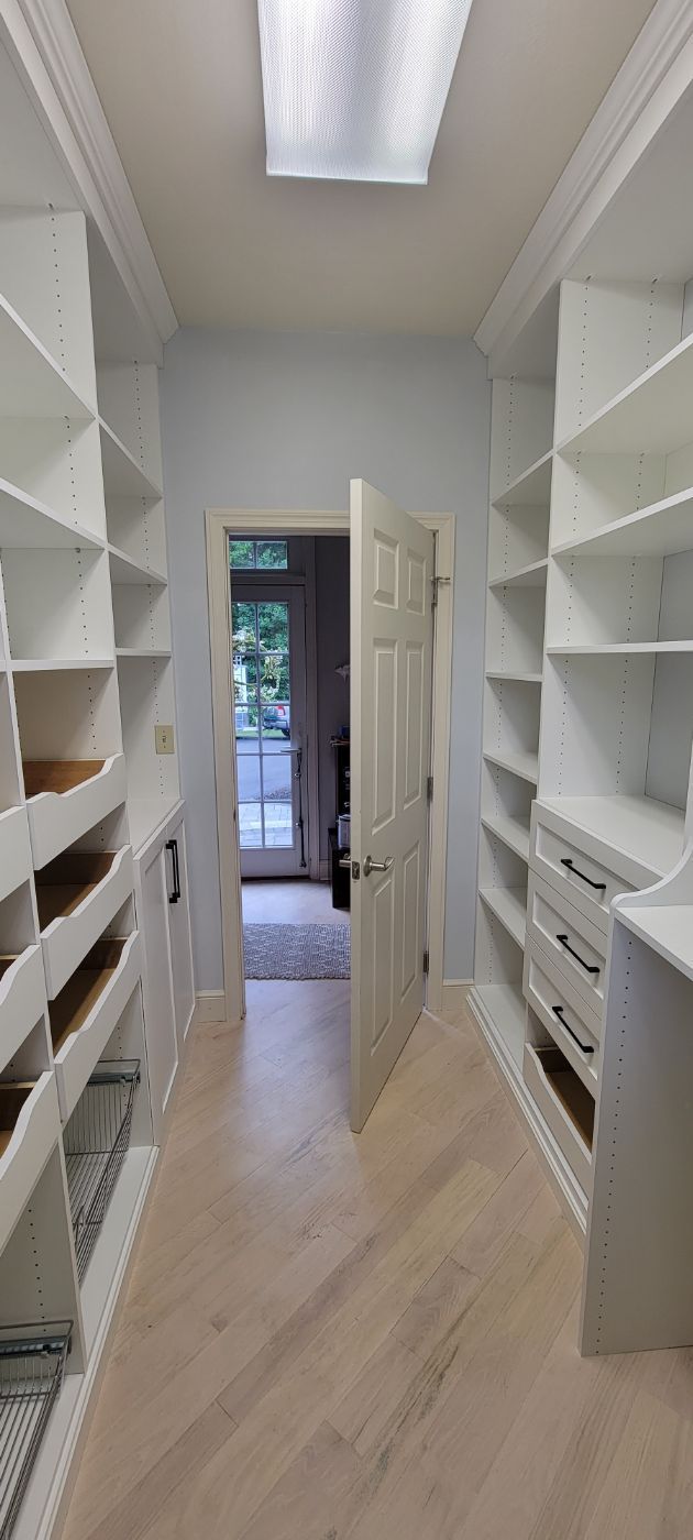 a walk in closet with lots of shelves and drawers .