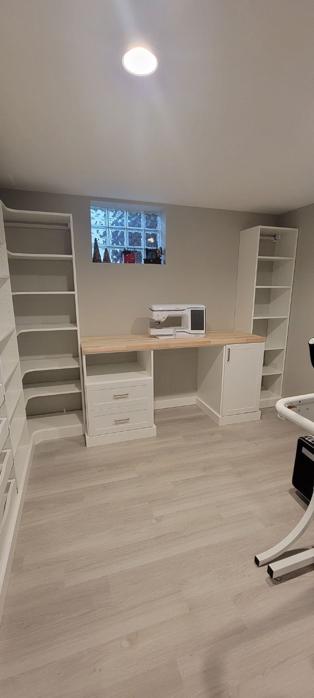 a room with a desk , shelves , and a window .