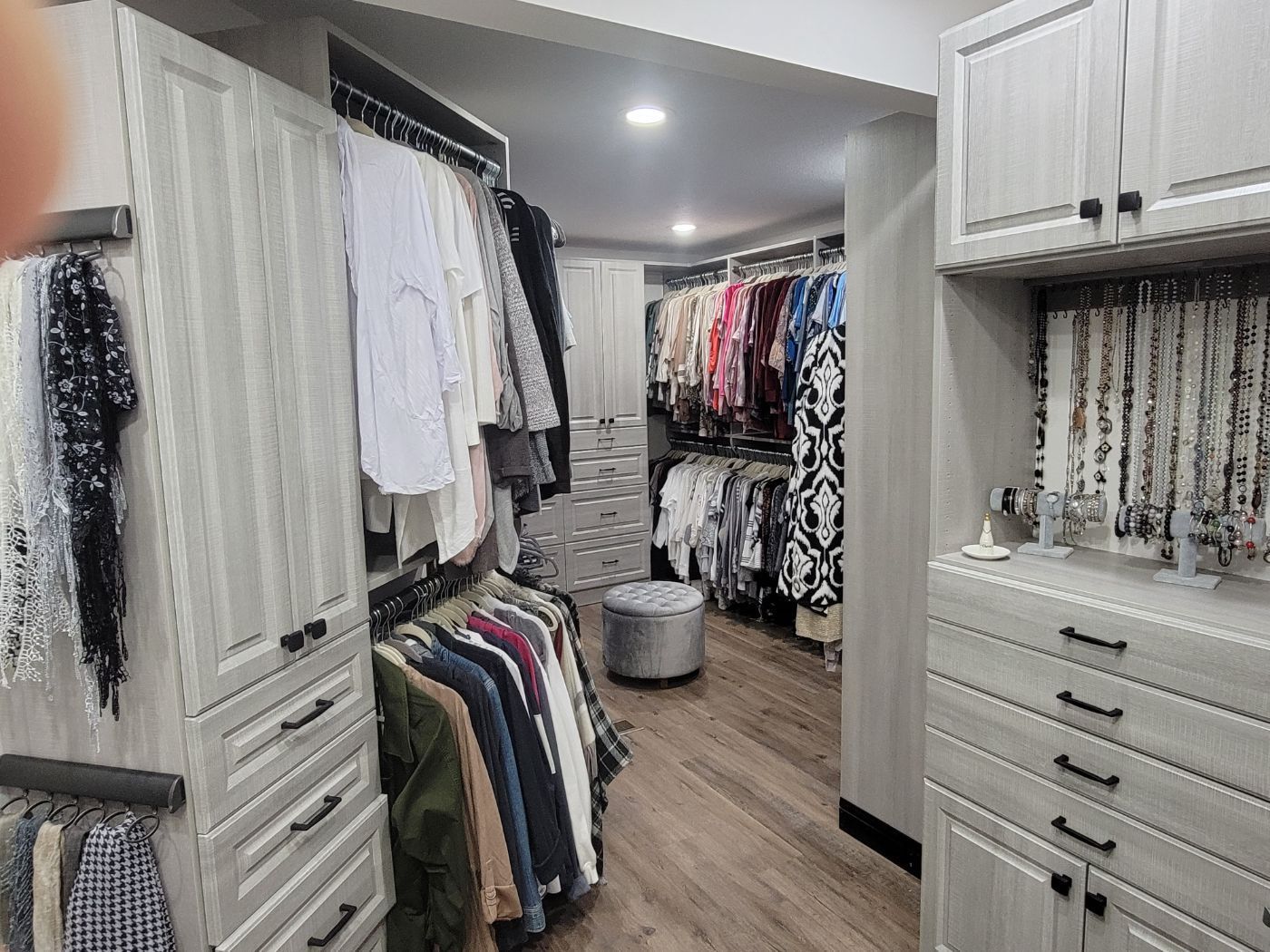 a walk in closet filled with lots of clothes and a dresser .
