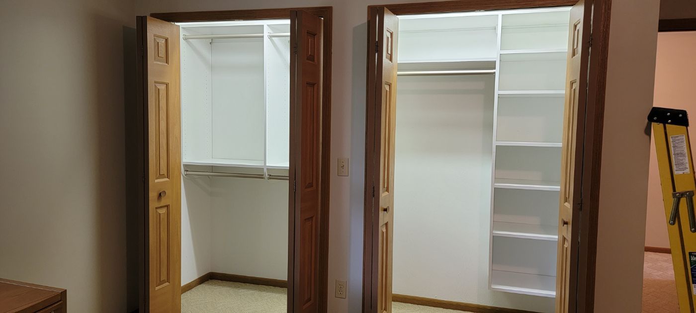 a walk in closet with two doors open and a ladder in the room .