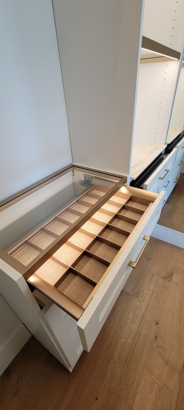 a closet with a drawer filled with wooden boxes and a mirror .