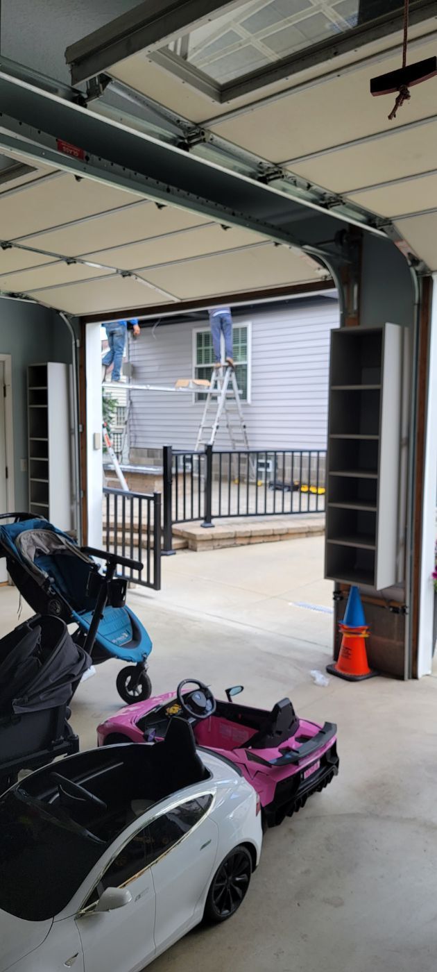 a garage with two cars and a stroller in it .