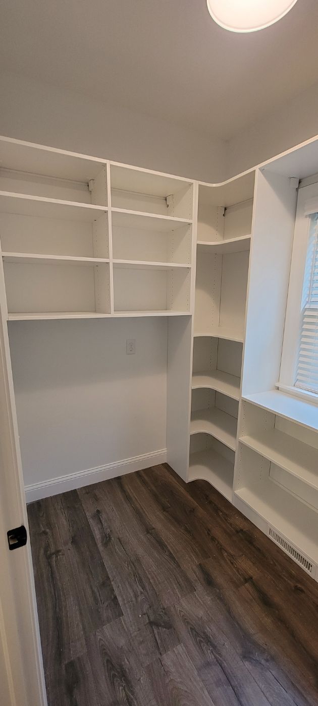 a closet with lots of shelves and a window .