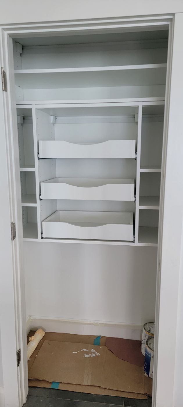 a closet with lots of shelves and drawers is being remodeled .