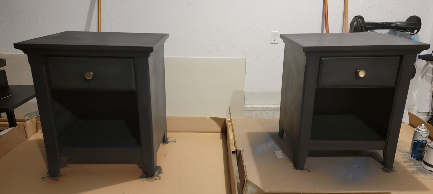two black nightstands are sitting on top of a cardboard box .