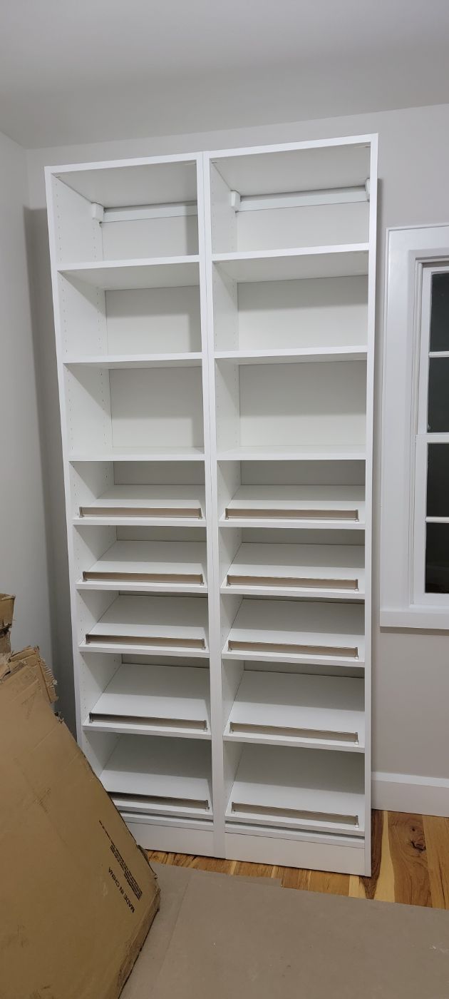 a pair of white shelves in a room next to a window .