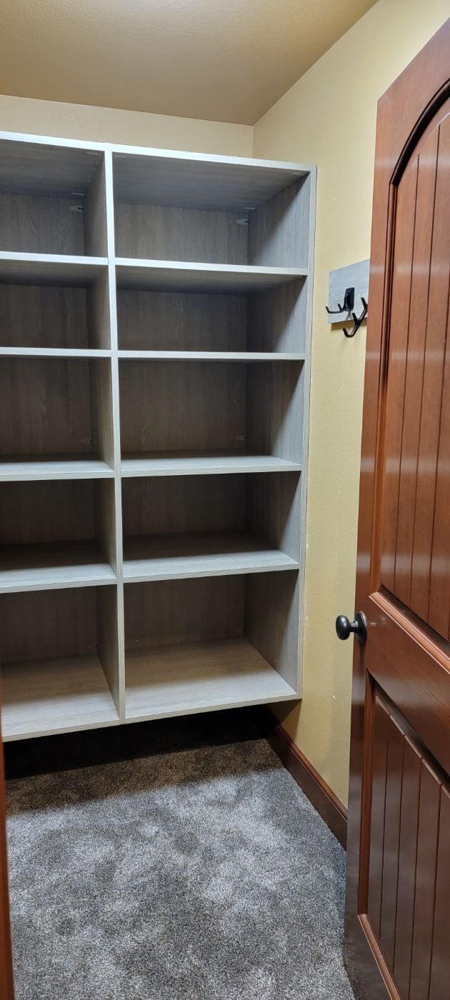 a closet with lots of shelves and a door .
