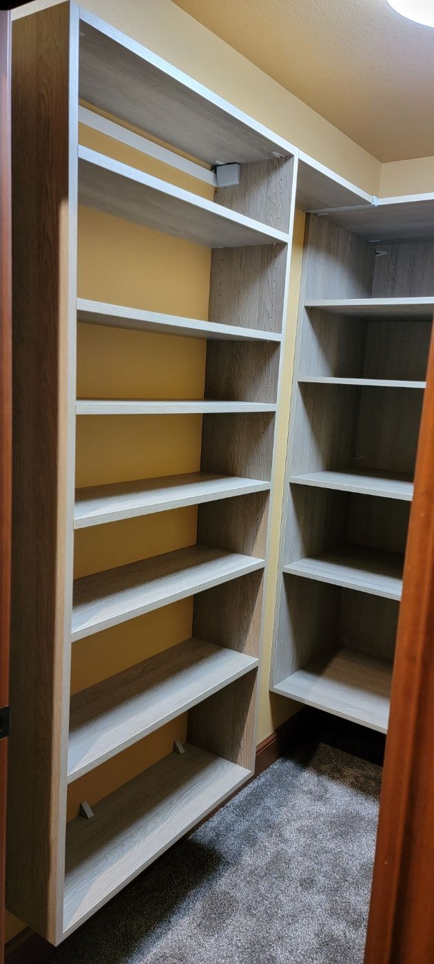 a closet with a lot of shelves and a door .
