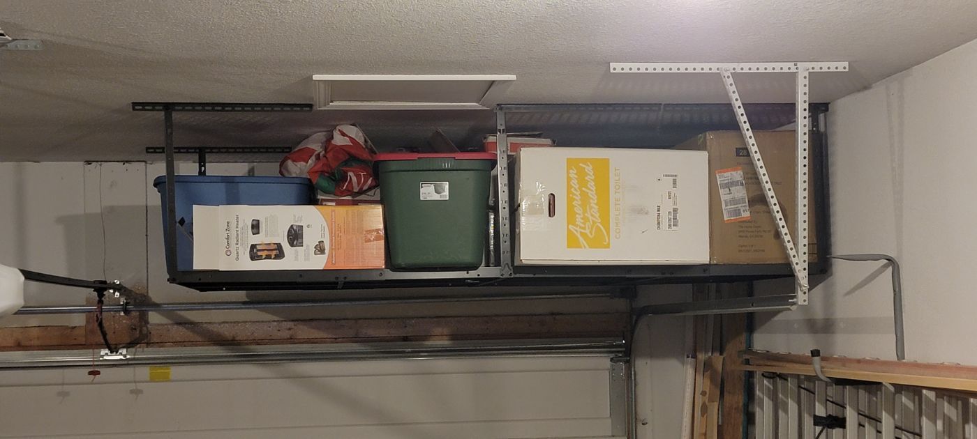 a garage filled with lots of boxes and shelves .