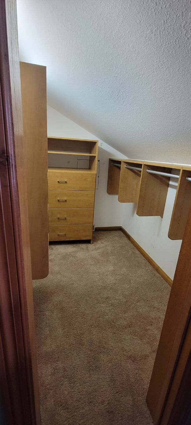 a walk in closet with a dresser , drawers , and curtains .