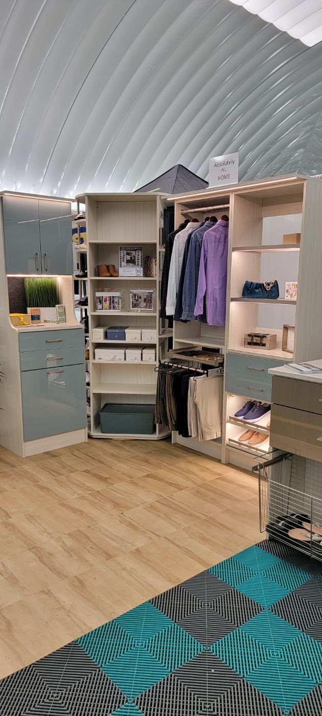 a walk in closet with clothes hanging on the shelves and a rug on the floor .
