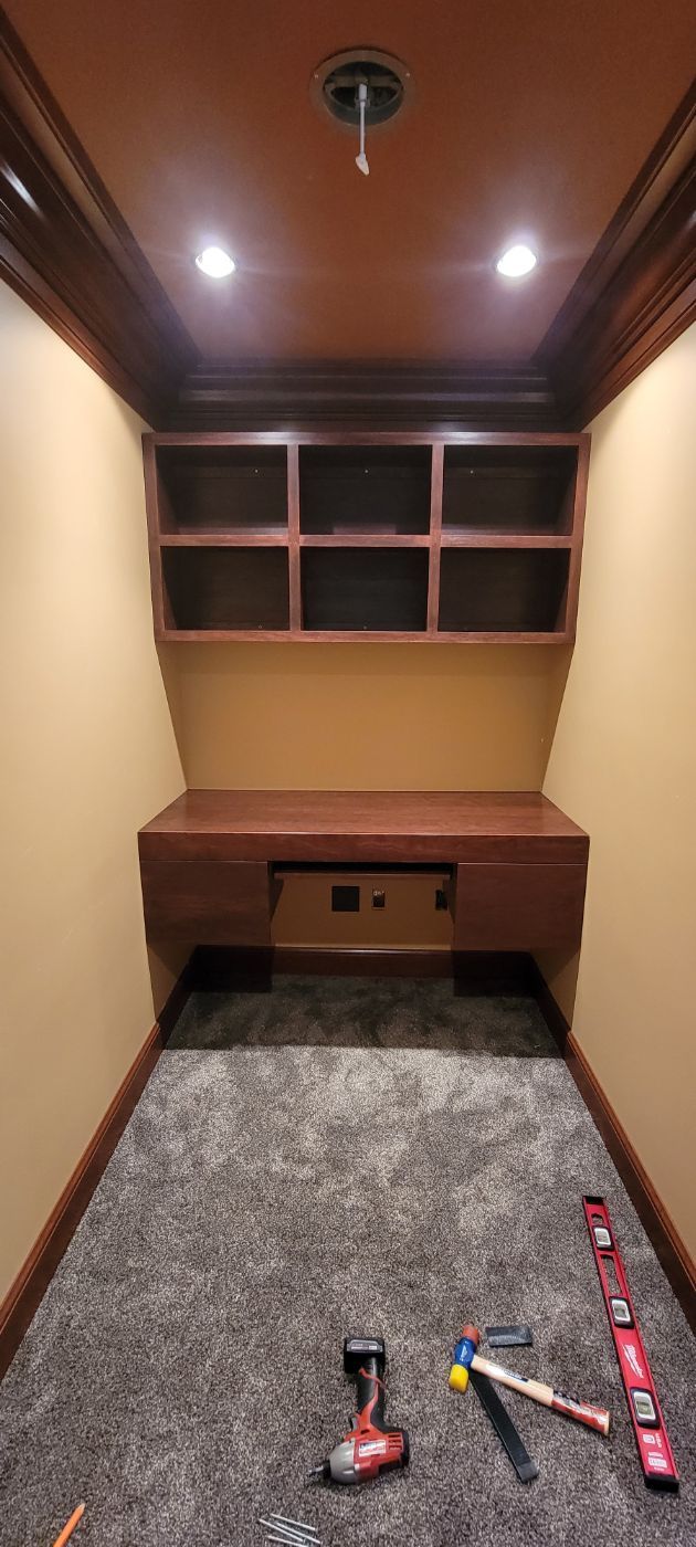 a small room with a desk and shelves and tools on the floor .