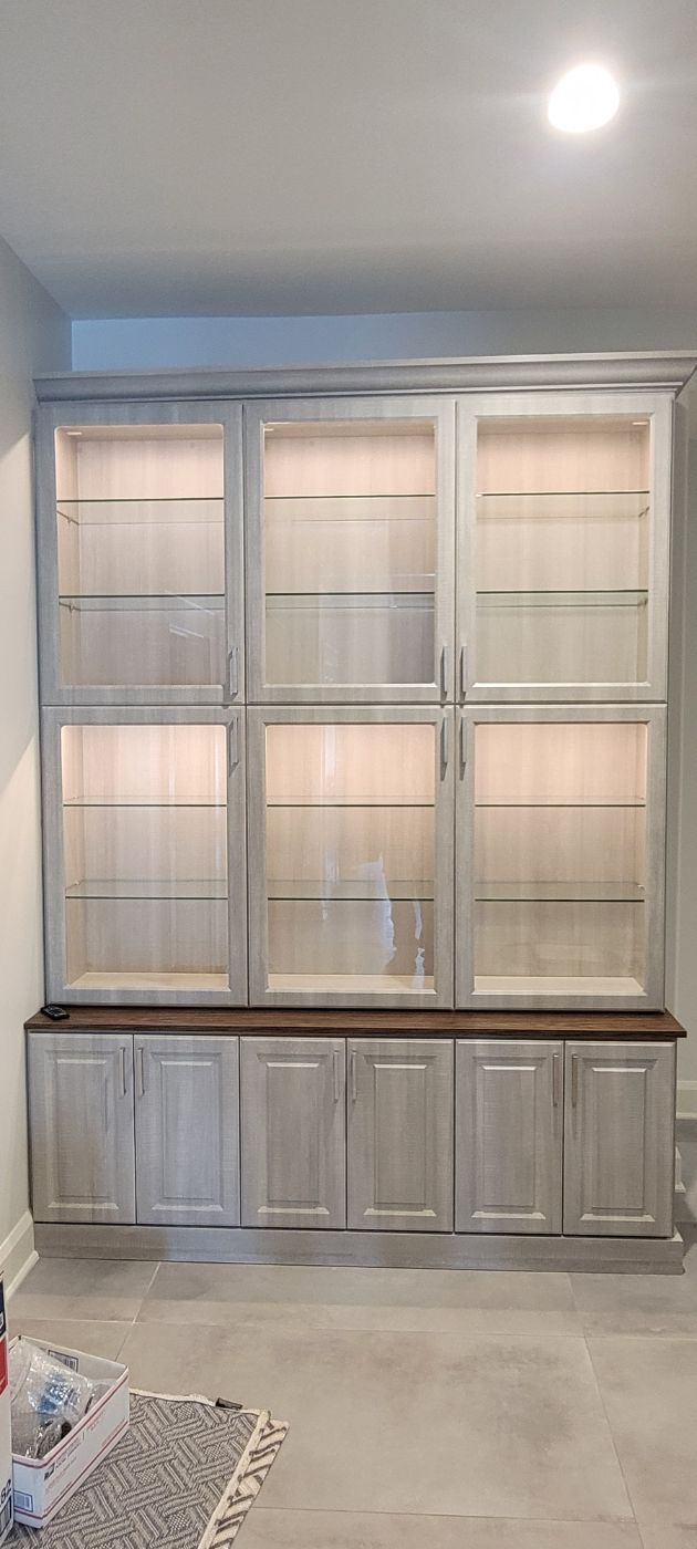 a room with a lot of cabinets and glass doors .