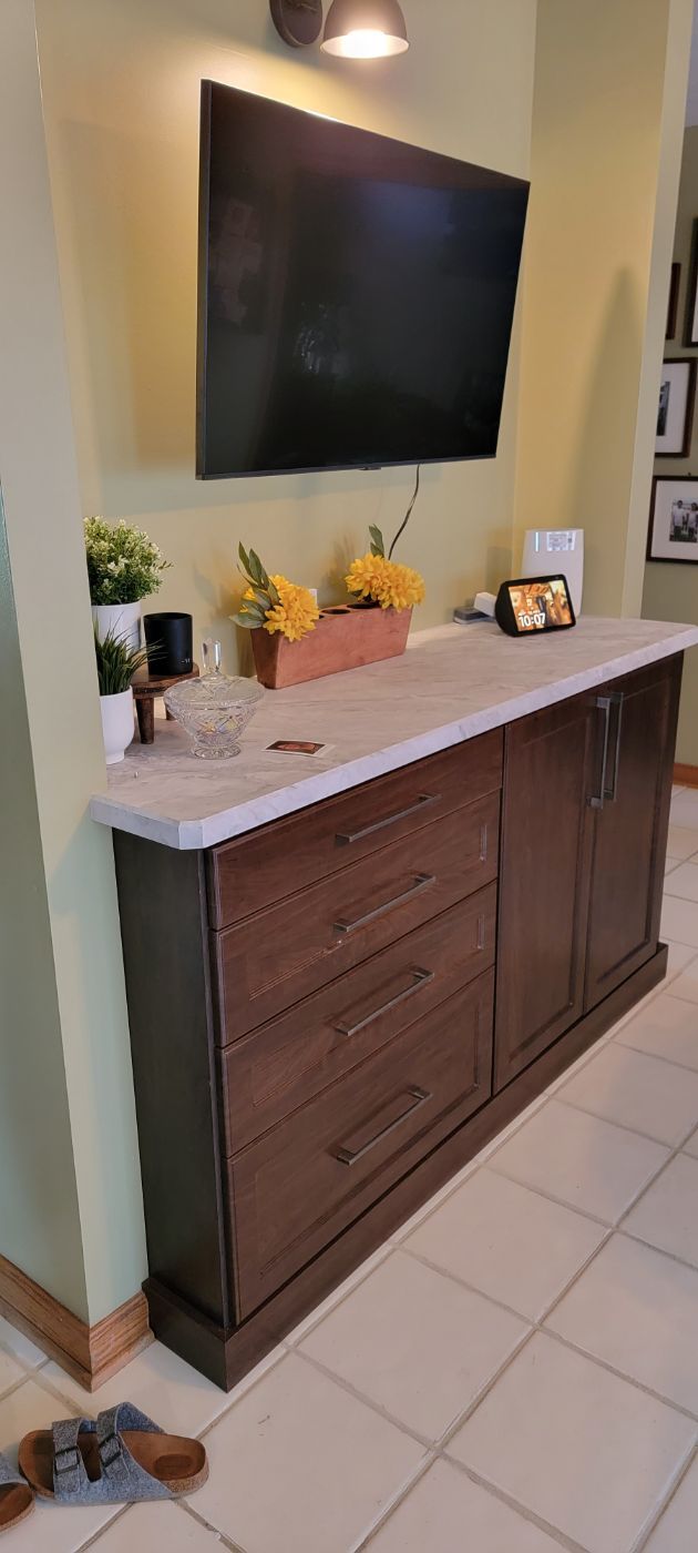 a dresser with drawers and a flat screen tv mounted to the wall .