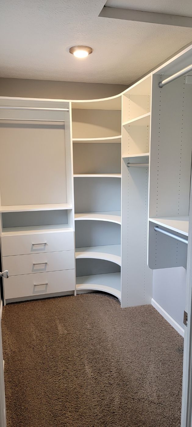 a walk in closet with a lot of shelves and drawers .