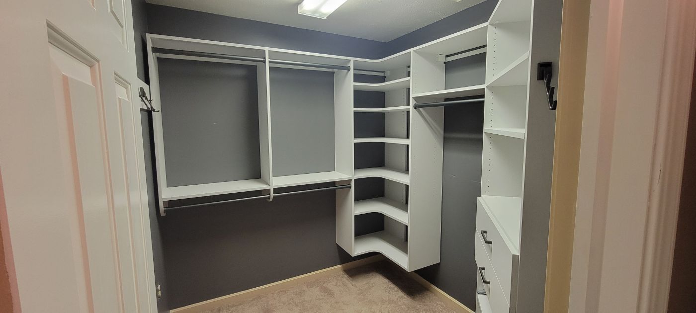 a walk in closet with a lot of shelves and drawers .