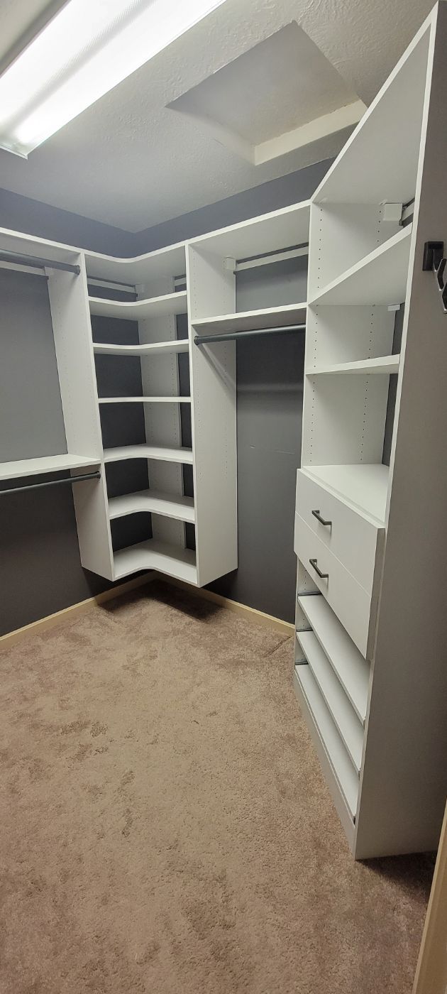 a walk in closet with a lot of shelves and drawers .
