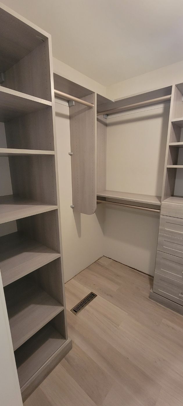 a walk in closet with lots of shelves and drawers .
