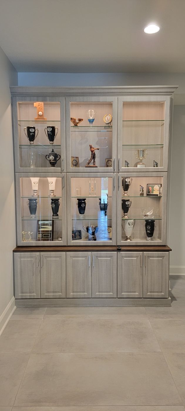 a living room with a display case filled with vases and glasses .