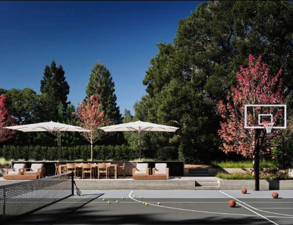 Private backyard basketball hoop beside a shaded patio and trees after a court installation service in San Tan Valley, AZ