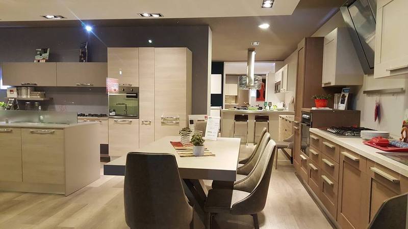 cucina con pensili color legno chiaro e penisola