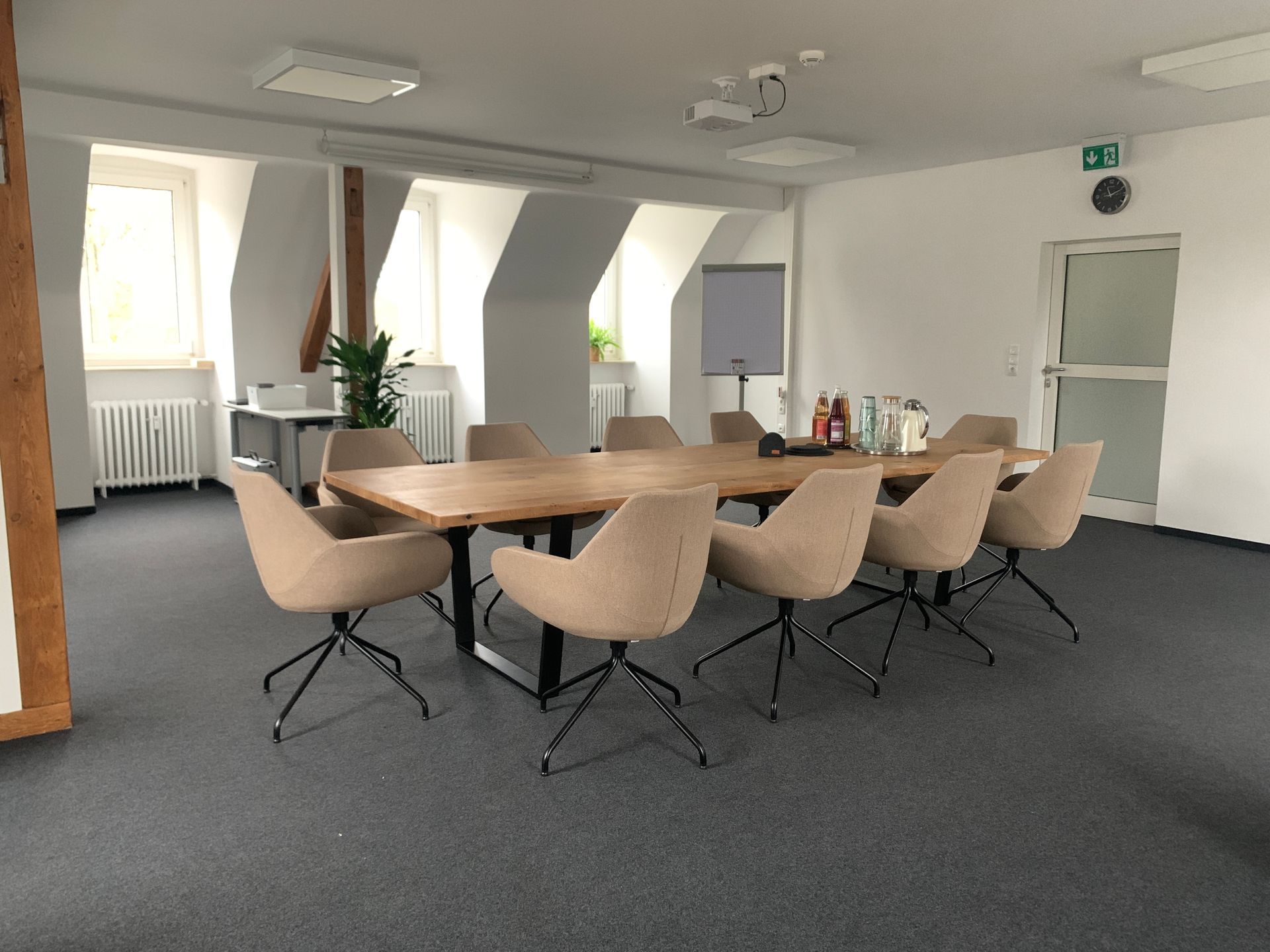 Ein Konferenzraum mit Tisch und Stühlen und einem Projektor.