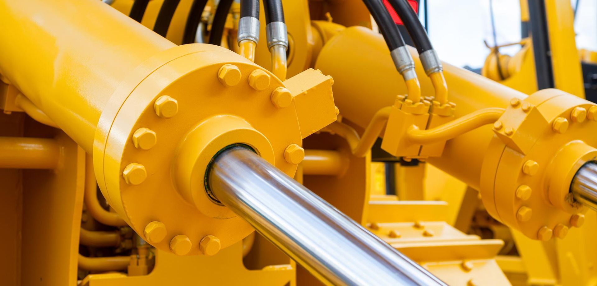 Close-up image of a yellow hydraulic machine with pipes, emphasizing its functionality for hydraulic cylinder repair in Bellevue, NE.