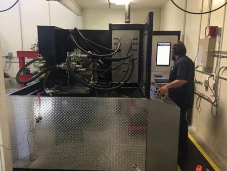 Man Is Standing In Front Of A Machine — Lincoln, NE — Central States Hydraulic Services