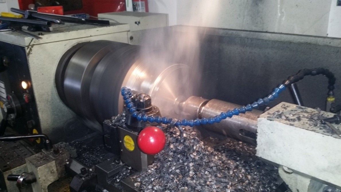 Lathe Is Cutting A Piece Of Metal In A Factory — Lincoln, NE — Central States Hydraulic Services