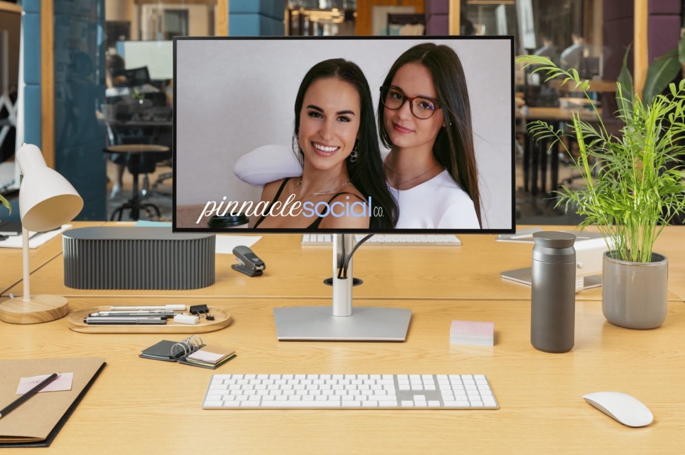 A computer monitor on a wooden desk displaying a photograph of two people with the text 