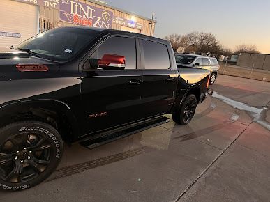 A black truck is parked in front of a building.
