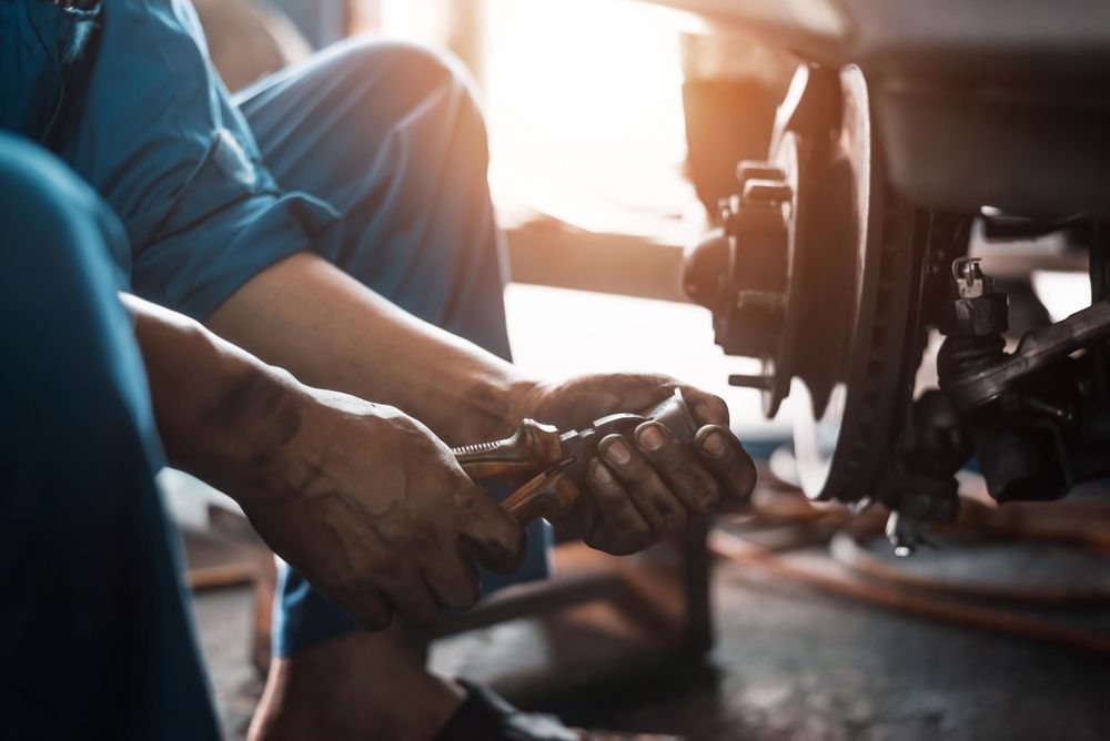 Mechanic Working on Car Brakes — A1 Mobile Safety Certificates in Edge Hill, QLD