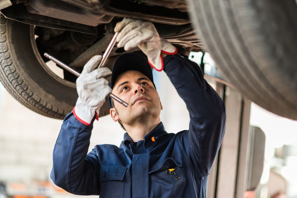 Mechanic repairing a raised car during a mobile vehicle inspection — Mobile Roadworthy in Smithfield, NSW
