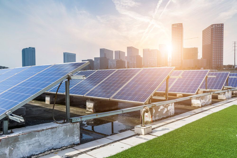 A Row of Solar Panels on Top of A Building with A City Skyline in The Background — Ryde Energy in Sunshine Coast, QLD