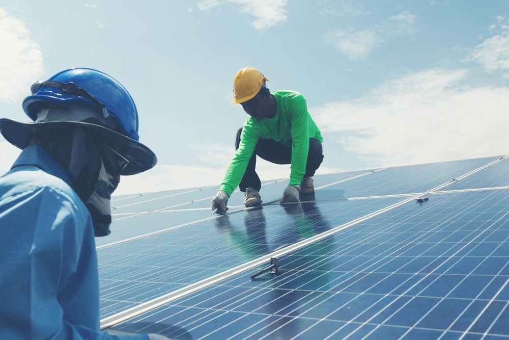 Two Men Are Working on A Solar Panel on Top of A Building — Ryde Energy in Flagstone, QLD